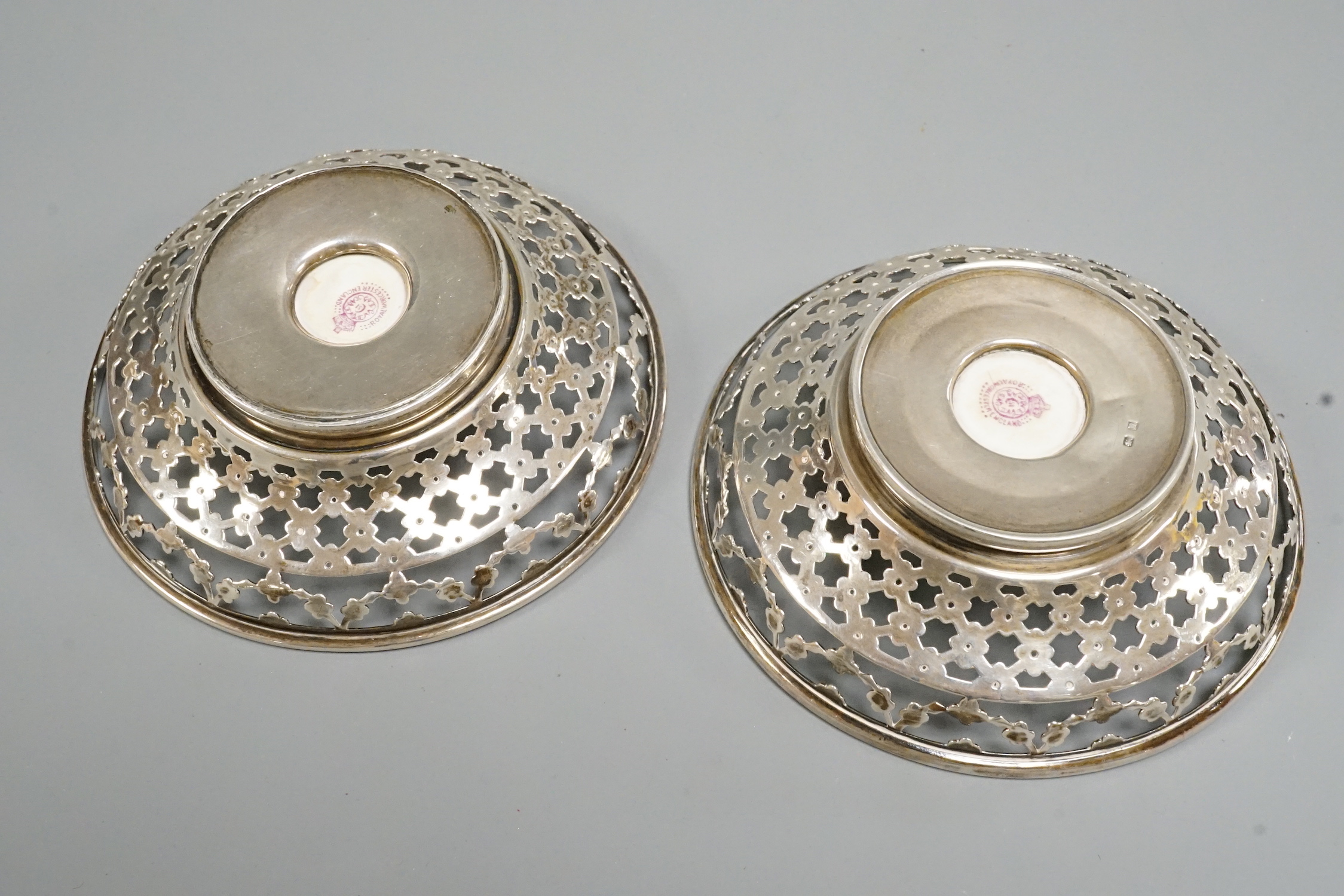 A pair of George V pierced silver mounted Royal Worcester panel bon bon dishes, painted by Raymond Rushton, hallmarked for Sanders & MacKenzie, Birmingham, 1912, diameter 10.5cm.